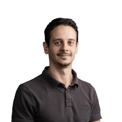 Ritratto di uomo sorridente con capelli castano scuro e polo nera