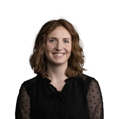 Donna sorridente con capelli ricci castani e blusa nera trasparente